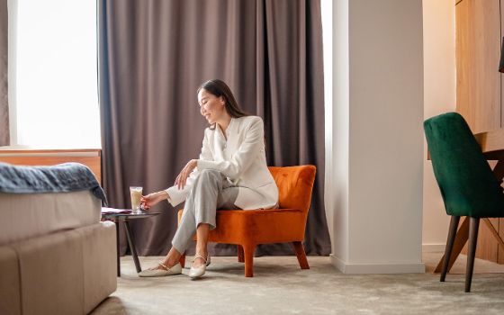 Eine Frau sitzt auf einem Stuhl in einem Hotelzimmer.