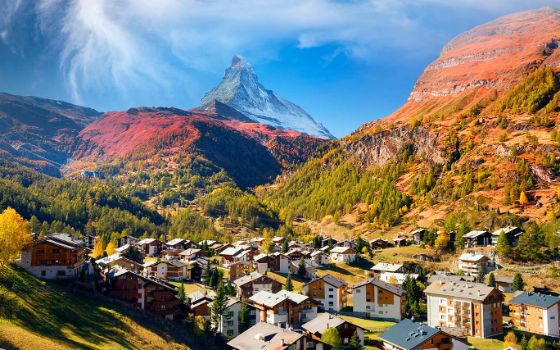 Umgeben von den Schweizer Bergen liegt ein kleines Dorf in einem Tal.