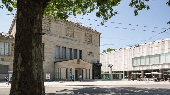 Aussenaufnahme vom Museumsgebäudekomplex des Kunsthaus Zürich an einem Platz, im Vordergrund ein Baum.