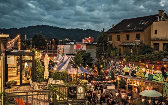 In einer Strasse in Zürich stehen verschieden Buden und Zelte, die geschmückt und beleuchtet sind. 