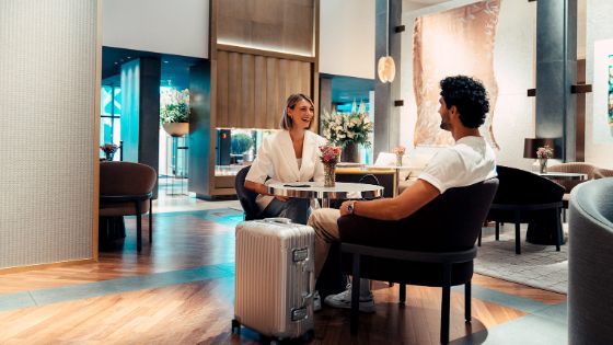 Eine Frau und ein Mann sitzen in der Lobby eines Hotels.