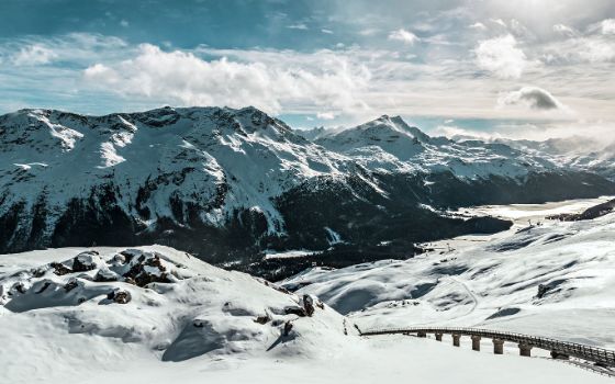 Verschneites Bergpanorama mit Seilbahntrasse in Schneelandschaft.