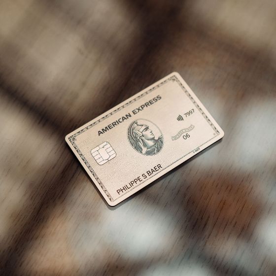Nahaufnahme einer American Express Platinum Card auf einer glänzenden Oberfläche mit Maserung.