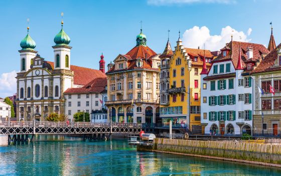 Historische Altstadt von Luzern mit Jesuitenkirche und bunten Bürgerhäusern am Reussufer, beliebtes Reiseziel mit American Express Vorteilen.