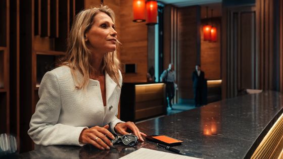 Eine Frau steht an einer Hotelrezeption.