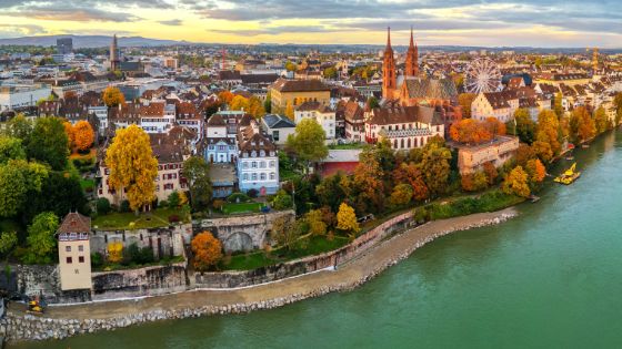 Herbstlicher Blick aus der Vogelperspektive auf das Basler Münster, die Altstadt und den Rhein bei Sonnenuntergang.