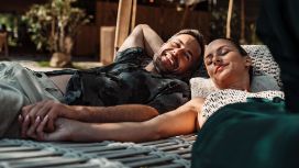 Paar entspannt gemeinsam in der Sonne auf einer Hängematte, genießt exklusive Auszeit mit American Express Vorteilen.