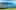 Blick auf den Genfersee mit den Alpen im Hintergrund, aufgenommen von einem Aussichtspunkt oberhalb der Lavaux-Region bei sonnigem Wetter.