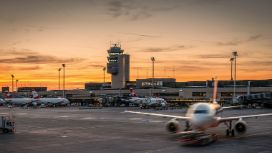 Die Landebahn des Flughafen in Zürich, vorne rollt ein Flugzeug ein, im Hintergrund sieht man den Tower.