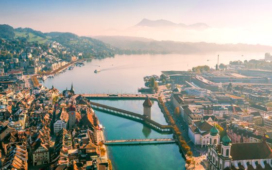 Luftaufnahme von Luzern mit Kapellbrücke, Wasserturm, Vierwaldstättersee und Pilatus im Hintergrund, exklusives Reiseziel mit American Express Vorteilen.
