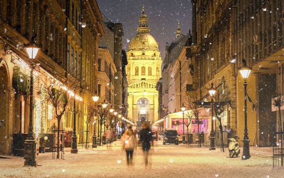 Beleuchtete Strasse in Budapest mit Blick auf die St.-Stephans-Basilika im Schneefall.