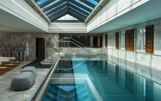 Moderner, heller Spabereich mit Pool unter einem Oberlicht.