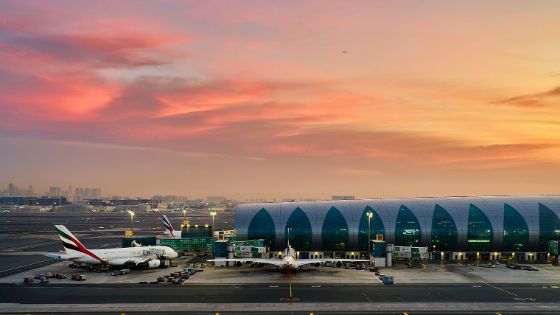 Auf der Rollbahn eines Flughafens steht ein Flugzeug vor einem Gebäude. 