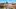 Altstadtpanorama von Lübeck mit Giebelhäusern, Backsteinkirchen und rundem Stadttor.