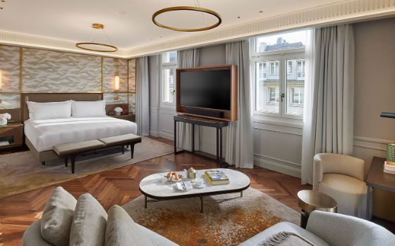 Helles, luxuriöses Hotelzimmer mit Parkettboden und modernem Interieur samt Doppelbett und Flachbildfernseher in Innenstadtlage.
