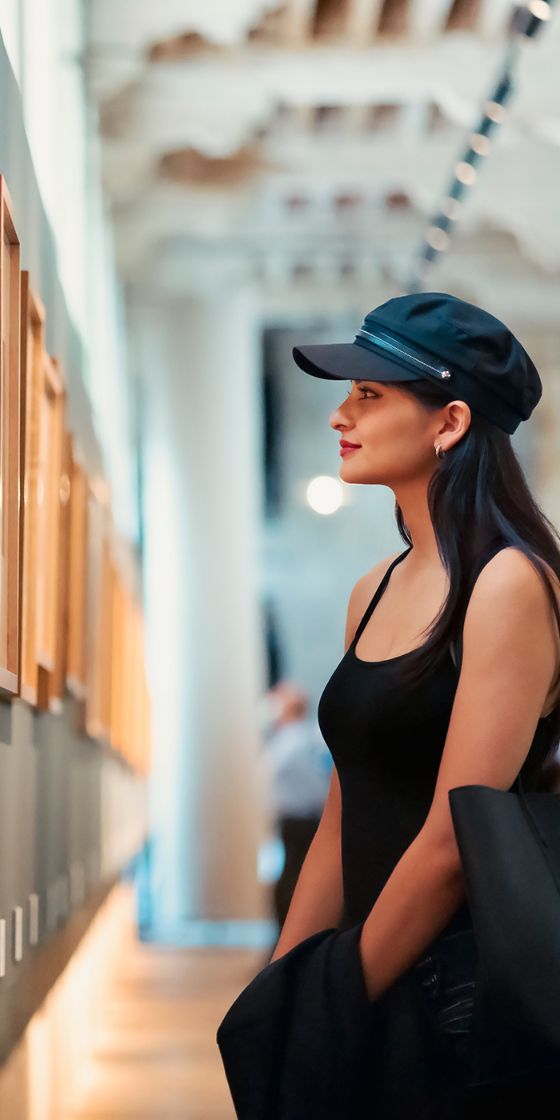 Eine Frau steht in einem Museum vor einem Kunstwerk.