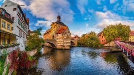 Ein historisches Rathaus mit Fachwerkhaus auf einer künstlichen Insel in einem Fluss in einer Altstadt.