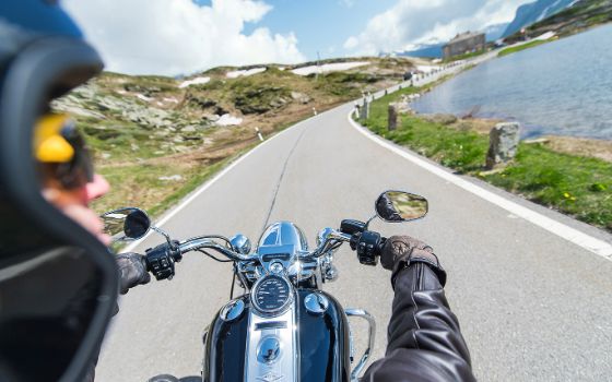 Ein Mann fährt auf einem Motorrad auf einer Strasse.