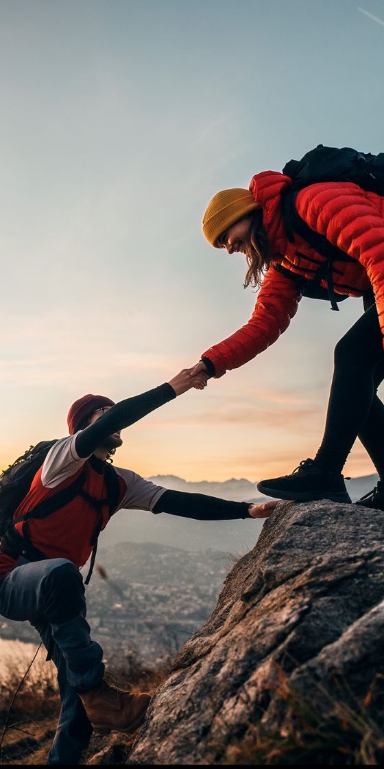 Ein Mann und eine Frau wandern einen steilen Berg hoch. 