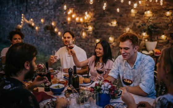 Gruppe von Menschen beim gemeinsamen Abendessen im Freien.