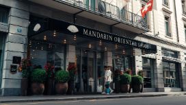 Ein Paar mit Trolley am Eingang des Luxushotels Mandarin Oriental Savoy im Stadtzentrum.