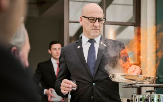 Der «Gastgeber des Jahres» 2024 Esteban Valle flambiert ein Gericht auf der Terrasse des Restaurants «Domaine de Châteauvieux»