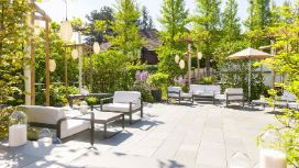 Im Garten des Restaurants Stucki stehen gemütliche Lounge-Möble bei herrlichem Wetter.