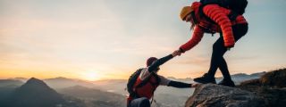 Ein Mann und eine Frau wandern einen steilen Berg hoch. 