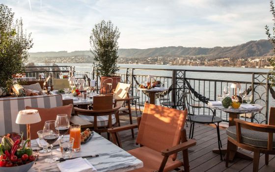 Die Dachterasse des Restaurants La Muna mit hochwertigen Sommermöbeln und elegant gedeckten Tischen.