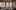 Lounge-Stühle stehen in einem gemütlichen Raum mit bodentiefen Fenstern, die Aussicht zeigt Berge mit Schnee.