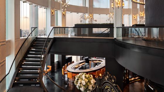 In einem lichtdurchfluteten Raum führt eine Treppe von einem Restaurant in die obere Etage.