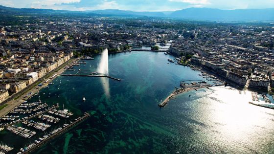 Luftaufnahme von Genf mit dem Jet d’Eau und dem Genfersee, umgeben von Altstadt und Stadtpanorama