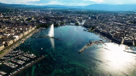 Luftaufnahme von Genf mit dem Jet d’Eau und dem Genfersee, umgeben von Altstadt und Stadtpanorama