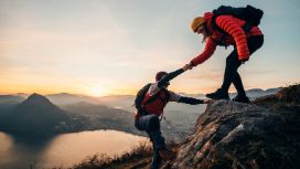 Ein Mann und eine Frau wandern einen steilen Berg hoch. 