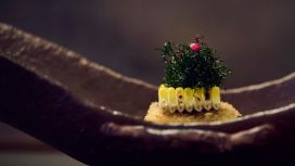 Eine moderne Vorspeise angerichtet in einer länglichen Schale, Mais-Tofu mit gebratenem Shiso-Blatt und Tonkatsu-Sauce.