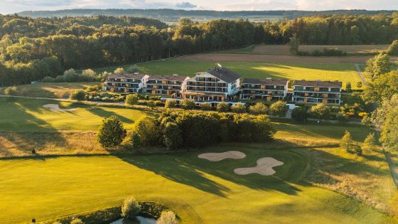 Ein Hotel liegt mitten in der Natur, umgeben von einem Golfplatz.