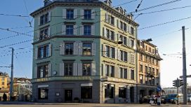Grün gestrichene Aussenfassade des Hotel Helvetia in einem freistehenden, klassizistischen Altbau im Züricher Stadtzentrum.