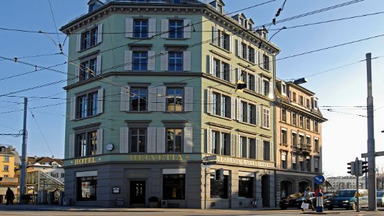 Grün gestrichene Aussenfassade des Hotel Helvetia in einem freistehenden, klassizistischen Altbau im Züricher Stadtzentrum.