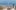 Blick vom Park Güell über die Dächer Barcelonas mit den beiden markanten Hochhäusern am Meer im Hintergrund.