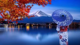 Eine Frau in einem Kimono hält einen Papierschirm und blickt auf den Berg Fuji in Japan. 