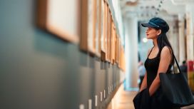 Eine Frau steht in einem Museum vor einem Kunstwerk.