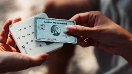 Kontaktlose Zahlung mit der American Express Platinum Kreditkarte an einem Kartenlesegerät in der Hand einer Person