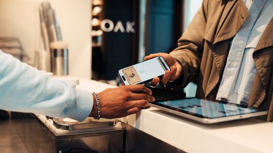 Eine Person hält ihre Smartwatch an ein Lesegerät zum bargeldlosen Bezahlen. 