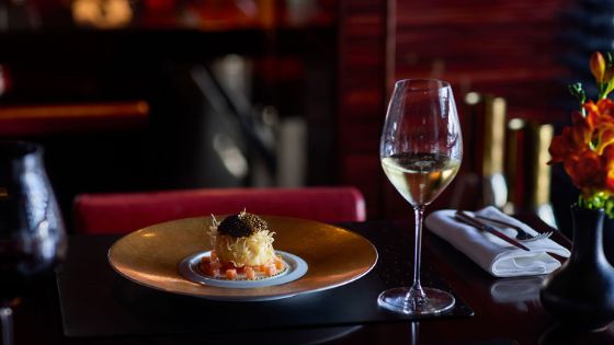 Ein elegantes Gericht mit einem Glas Weisswein im Restaurant L’Atelier Robuchon. 