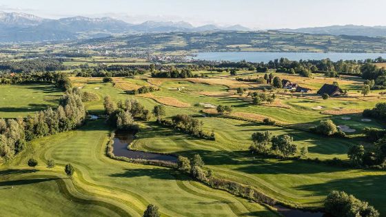 Ein grosser Golfplatz liegt in der Nähe eines Sees. 